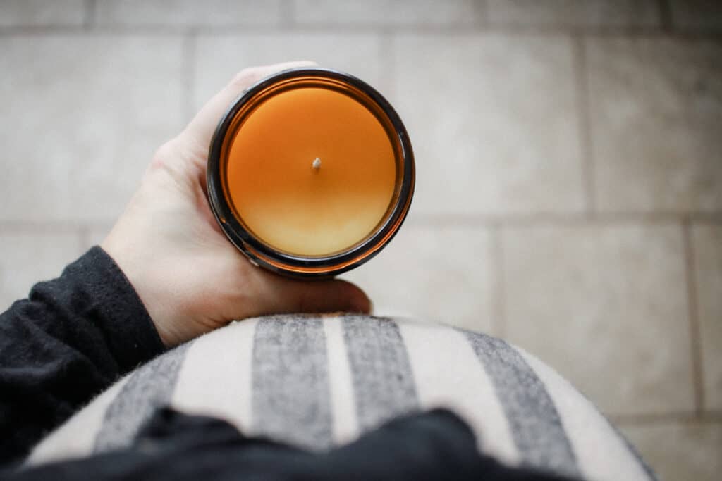 pregnant woman holding freshly poured candle 